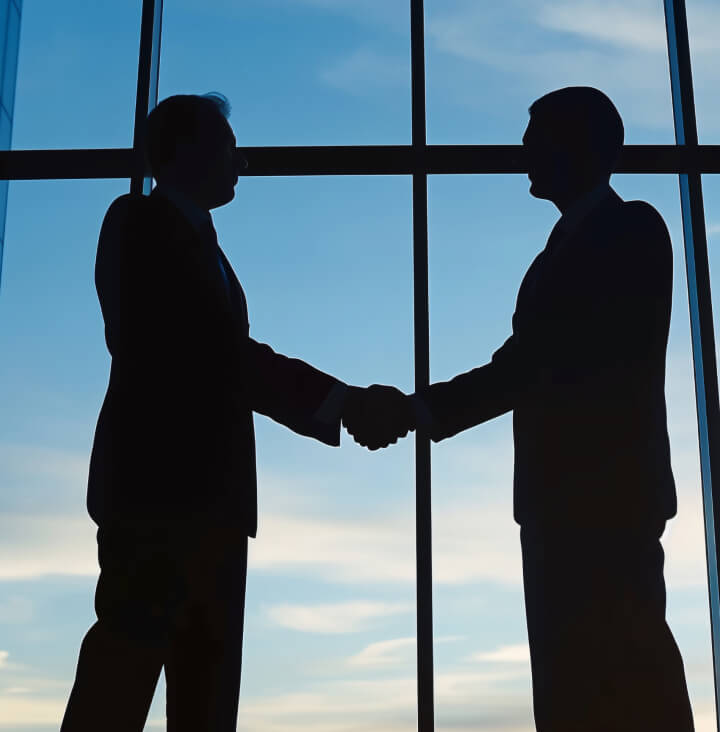 握手している2人の男性のシルエット